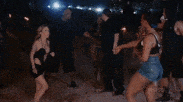 a group of people are standing around a woman in a bikini .