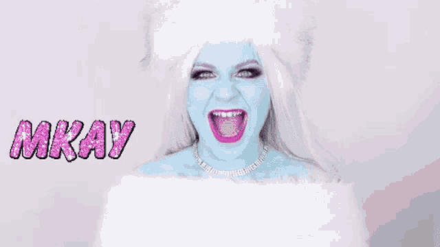 a woman with blue paint on her face is wearing a white fur hat and a white fur coat .