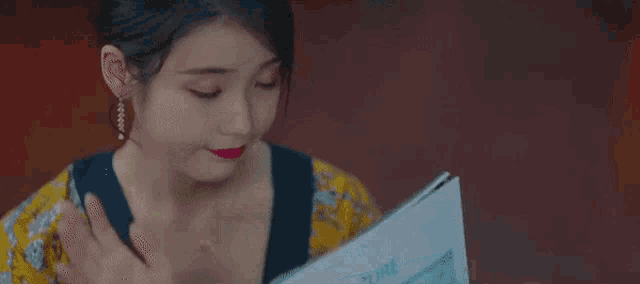 a woman with red lipstick is holding a piece of paper that says azure .