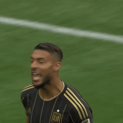 a soccer player wearing a black and gold jersey that says lmt on it