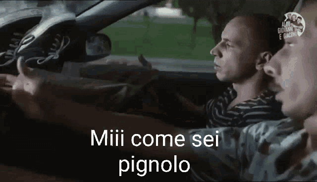 two men are sitting in a car and one of them is giving a thumbs up