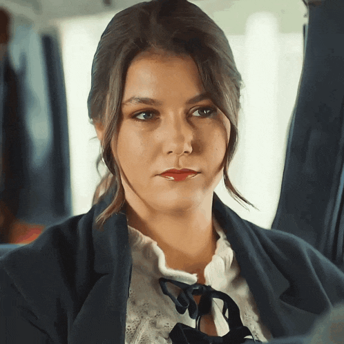 a close up of a woman 's face with a blue jacket on
