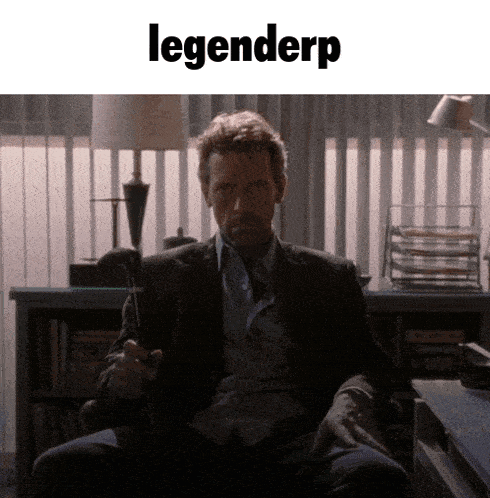 a man in a suit sits in a chair with the word legenderp on the bottom