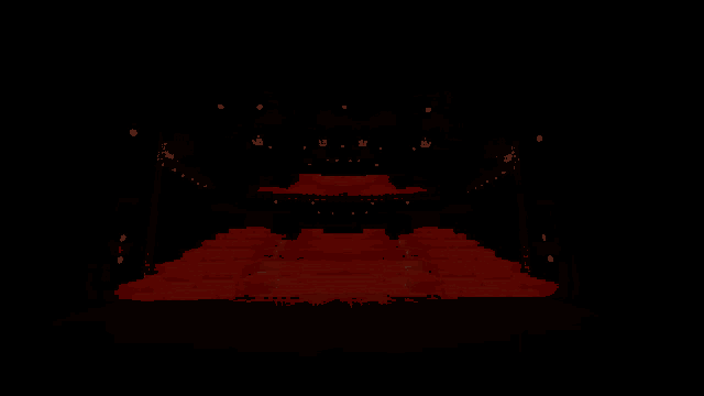 a dark auditorium with red seats and a stage