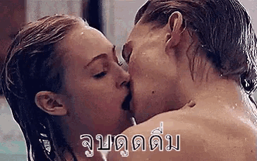 a man and a woman are kissing in the water .