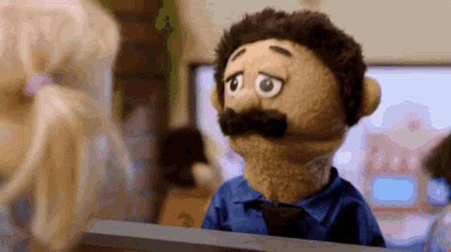 a puppet with a blue shirt and tie looks sad
