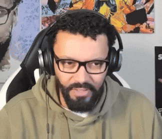 a man with a beard and glasses is wearing headphones .