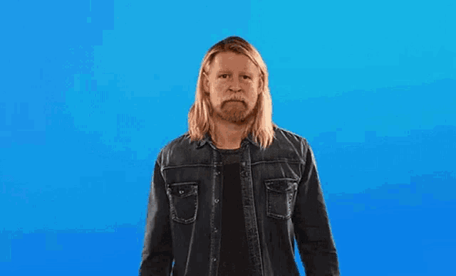 a man with long hair and a beard is giving the middle finger in front of a blue background that says this