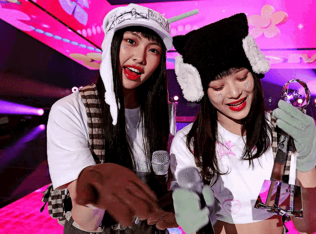 a couple of girls standing next to each other with a microphone