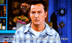 a man in a plaid shirt is talking to another man in a room .