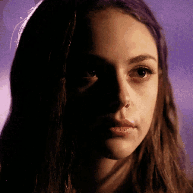 a close up of a woman 's face in a dark room