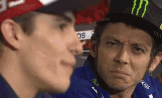 a man wearing a monster hat is looking at another man .