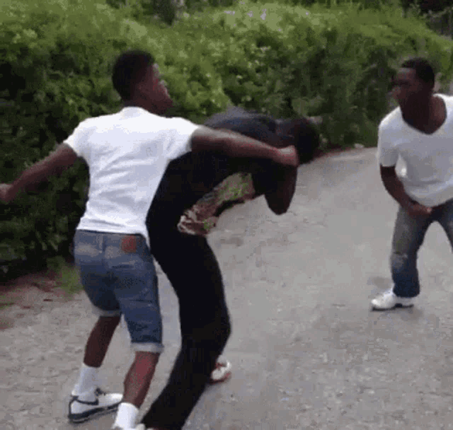 a man in a white shirt is carrying another man