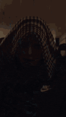 a close up of a person wearing a scarf and a mask with a tattoo on their face .