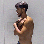 a shirtless man is standing in front of a door .