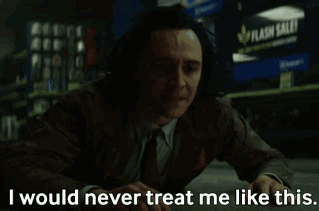 a man in a suit and tie is sitting at a table and says `` i would never treat me like this '' .