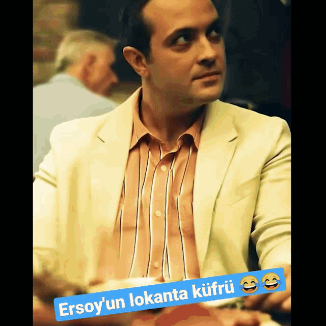 a man in a suit is sitting at a table with a caption that says ersoy 'un lokanta kufru