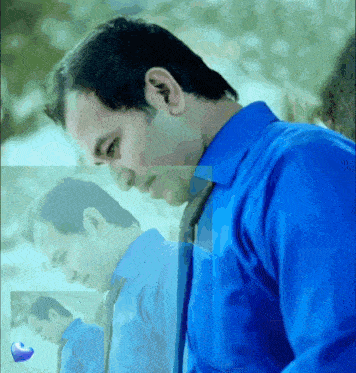 a man in a blue shirt is looking down