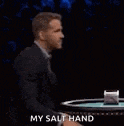 a man in a suit is making a stop gesture with his hand .