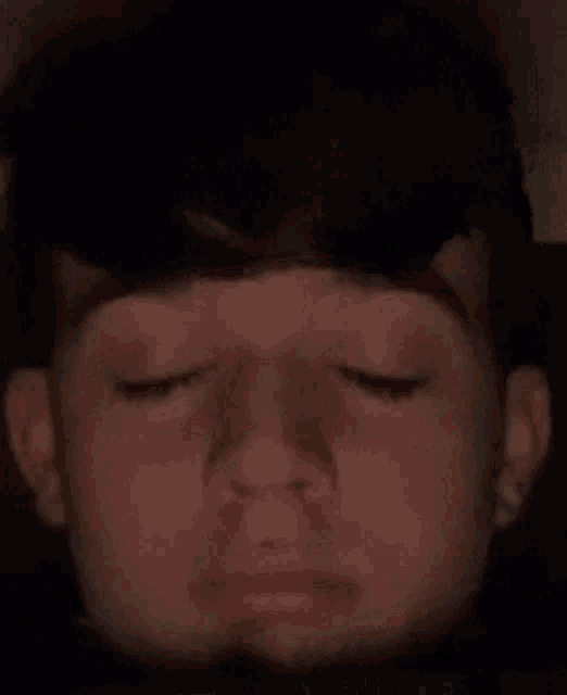 a close up of a person 's face with their eyes closed and their mouth open