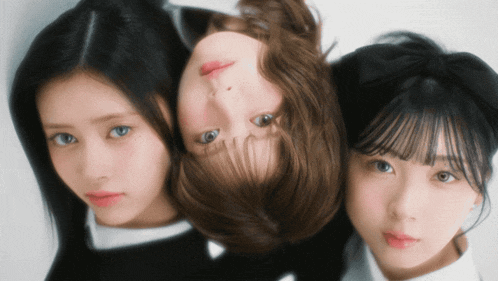 three girls are posing for a picture and one has her head in the middle