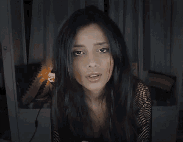 a woman with long dark hair is making a funny face with her eyes closed