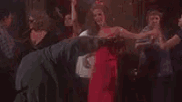 a group of people are dancing together in a dark room .