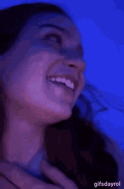 a close up of a woman 's face with her mouth open and teeth visible .