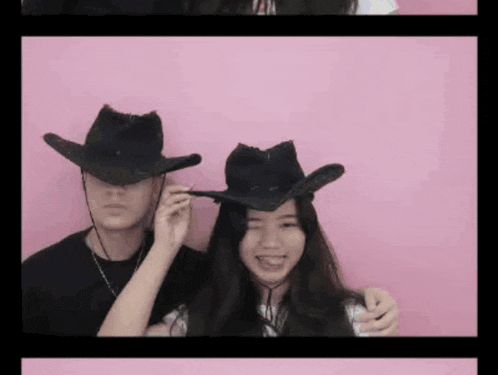 a man and a woman wearing cowboy hats against a pink wall