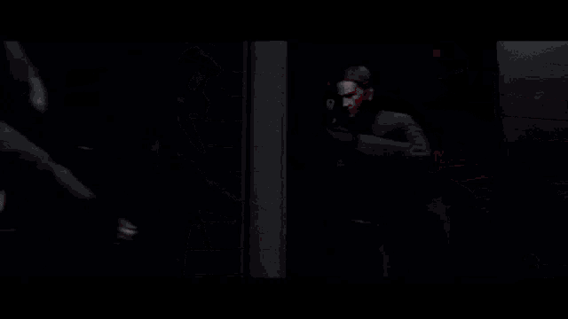 a man shooting a gun in a dark room