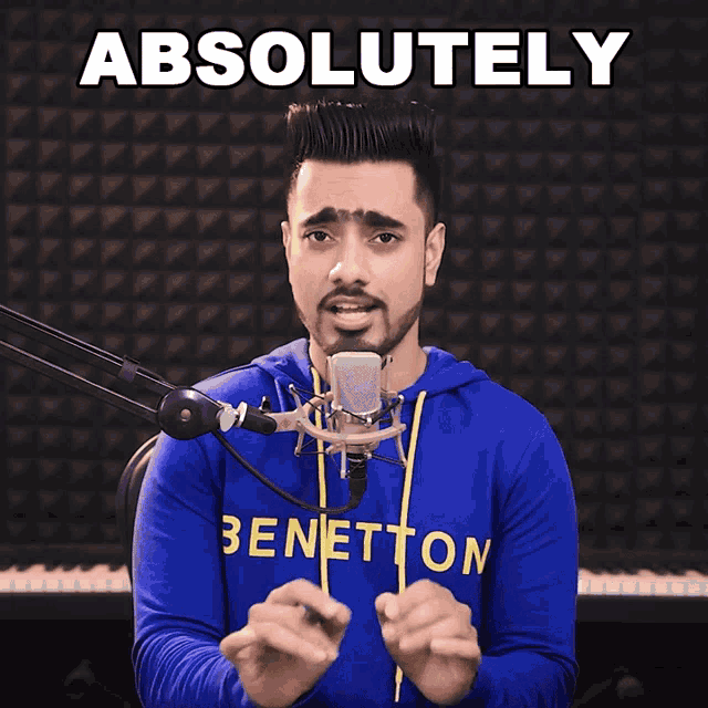 a man singing into a microphone with the words " absolutely " above him