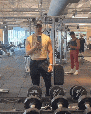 a man taking a picture of himself in a gym with dumbbells that say 2 lb