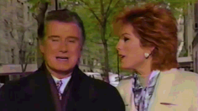 a man and a woman are talking to each other on a street