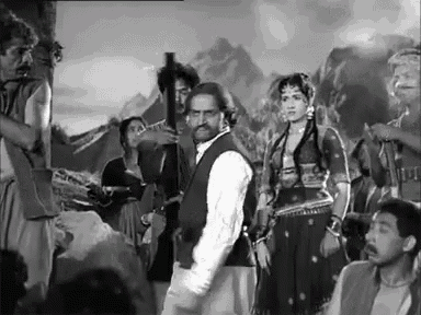 a group of people are standing around a man holding a gun .