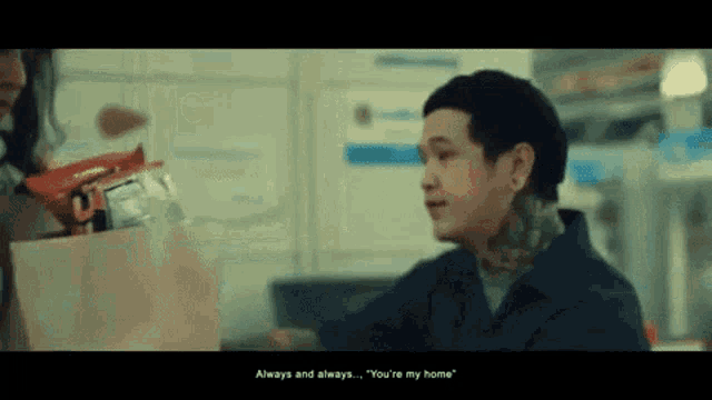 a man with a tattoo is talking to a woman in a store .