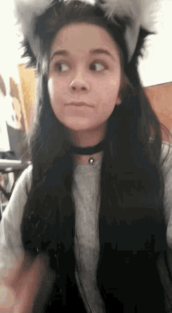 a girl wearing a choker and cat ears looks to the side