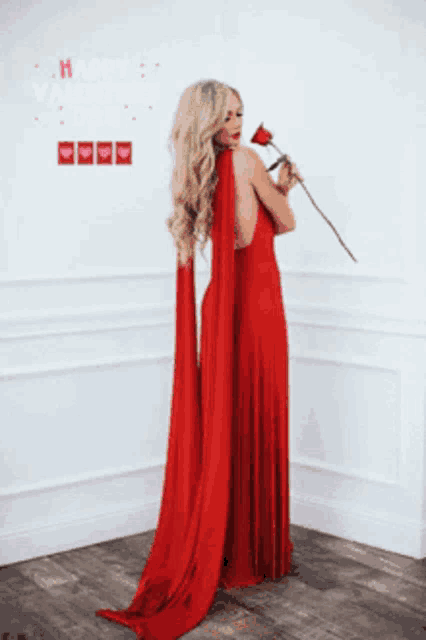 a woman in a red dress holding a red rose