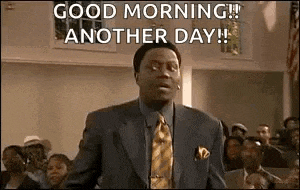 a man in a suit and tie is standing in front of a crowd and saying `` good morning ! ''