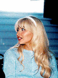 a blonde woman wearing a blue sweater and a headband