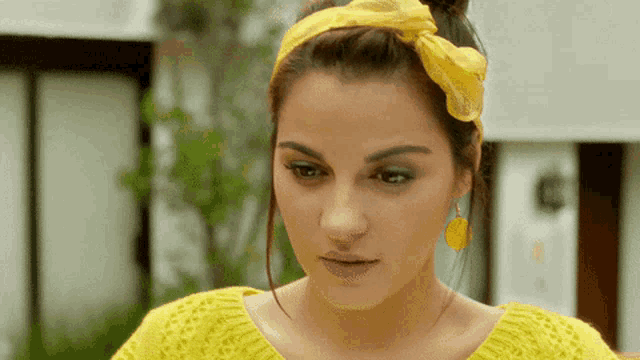 a woman wearing a yellow sweater and a yellow head scarf