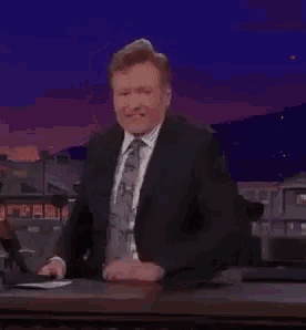 a man in a suit and tie clapping his hands