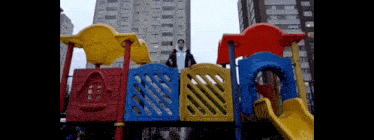 a man standing on top of a colorful playground set