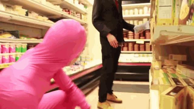 a man in a suit is standing next to a woman in a pink suit