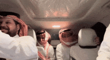 a group of people are sitting in the back seat of a vehicle