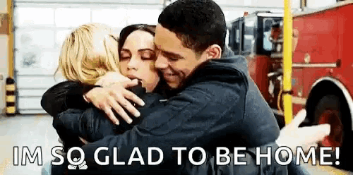 a man and a woman are hugging each other in front of a fire truck .