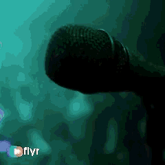 a blurry picture of a person holding a microphone with flyr written on the bottom right