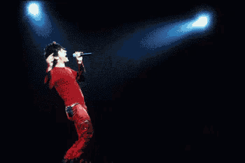 a man singing into a microphone with the words indo chine behind him