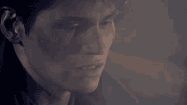 a close up of a man 's face with smoke coming out of it .