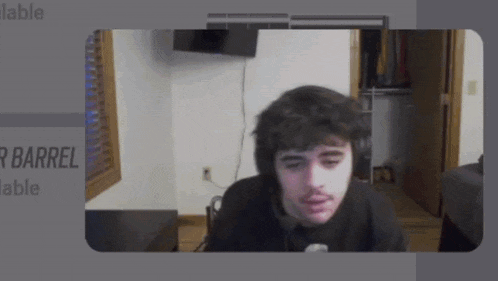 a man wearing headphones is sitting in front of a screen that says r barrel