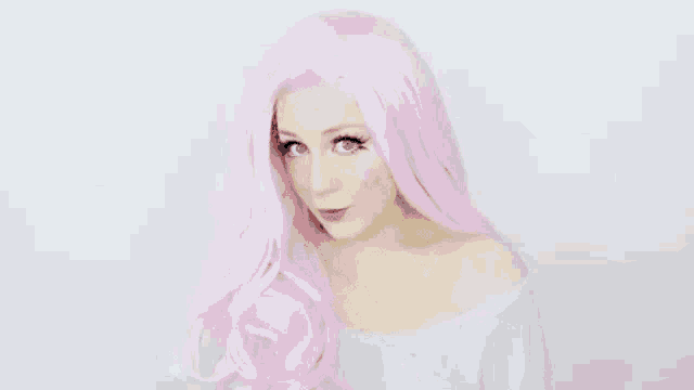 a woman in a pink wig is blowing a kiss at the camera .